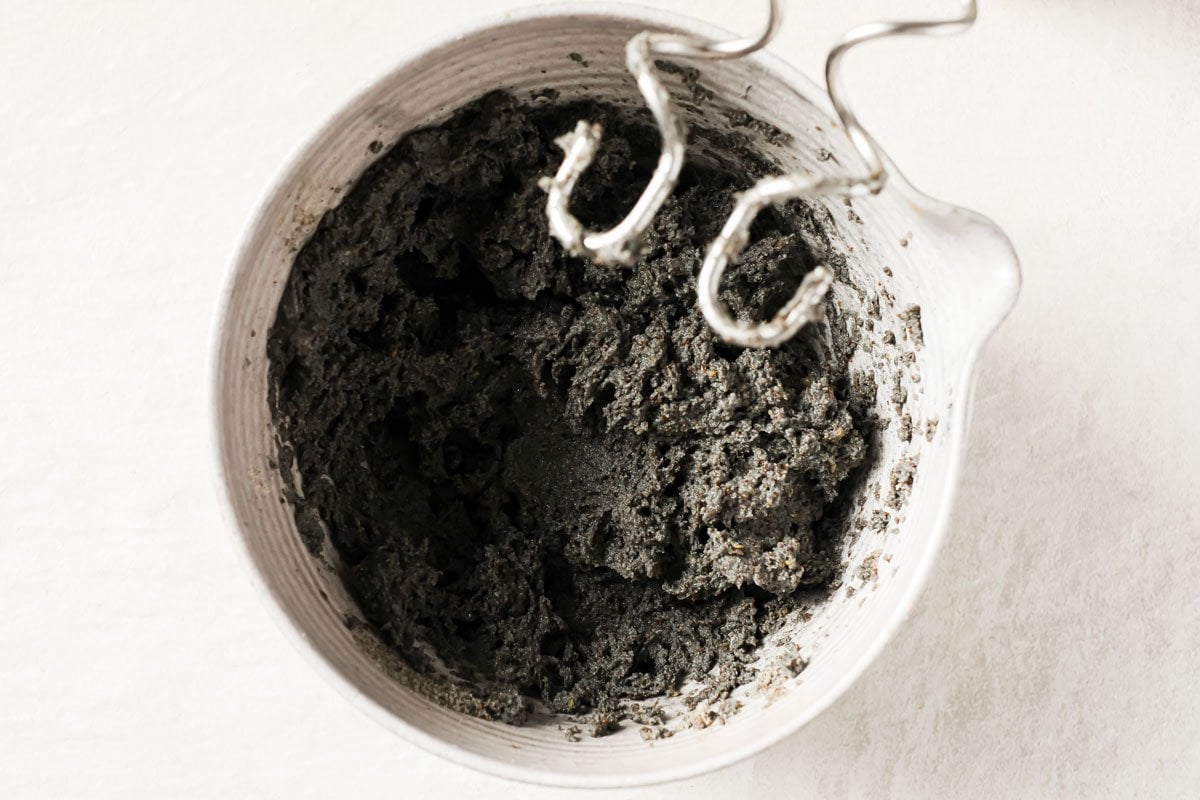 black dough in a bowl with dough hooks