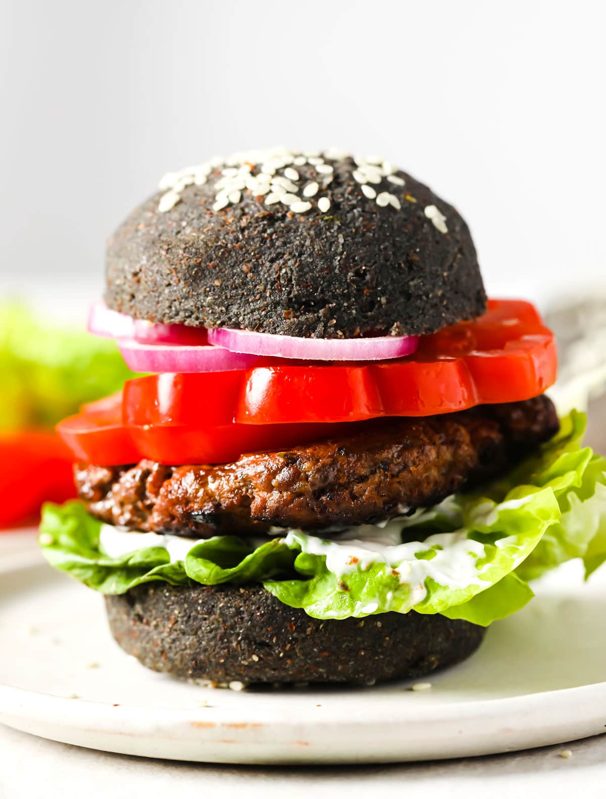 A hamburger with a black burger bun