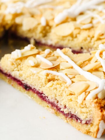 a slice of tart topped with flaked almonds and icing