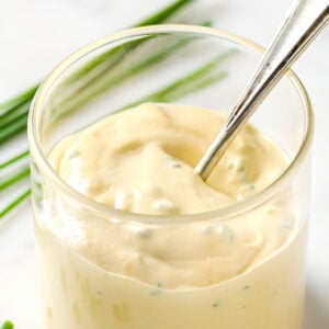 caesar dressing in a glass and a spoon