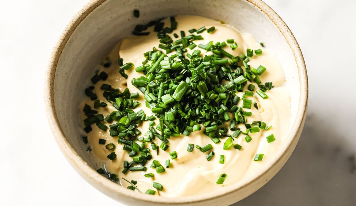 chopped chives on a bowl with salad dressing