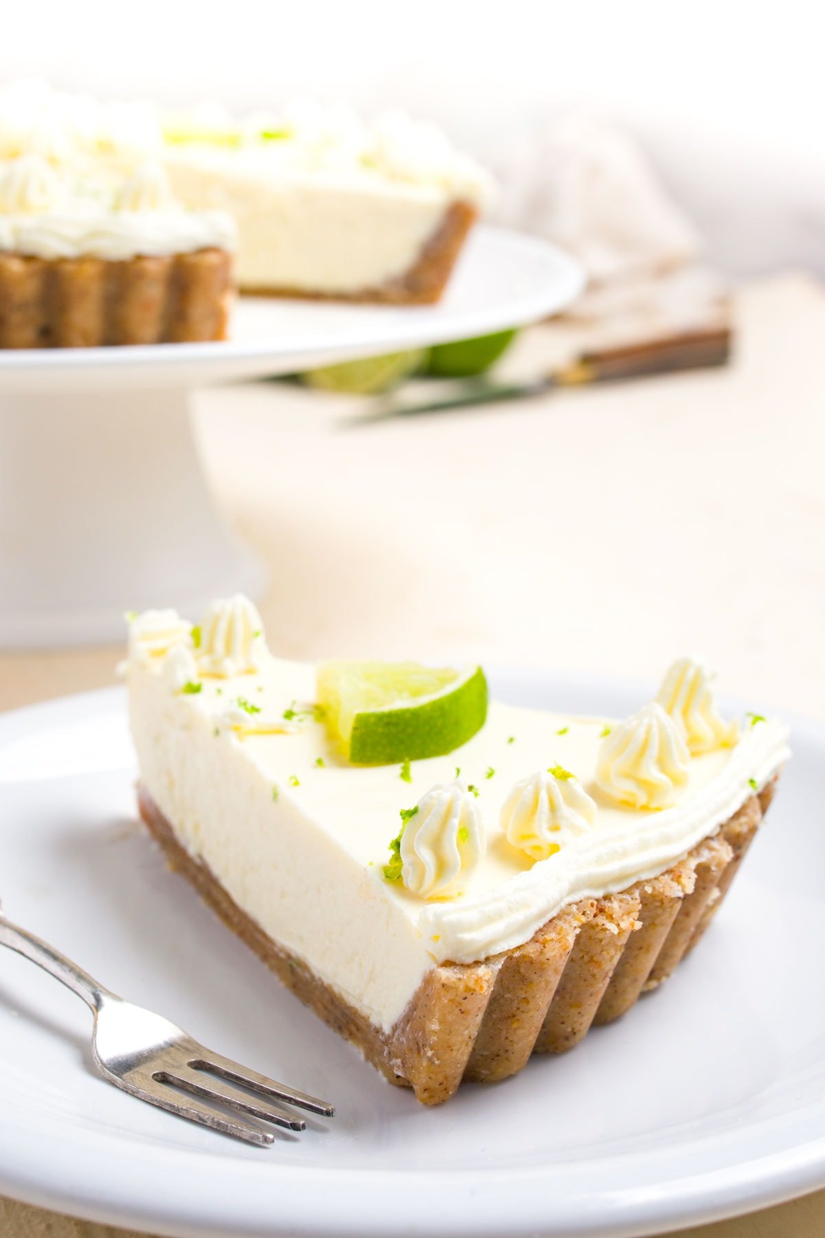 A slice of lime pie on a plate with a fork. 