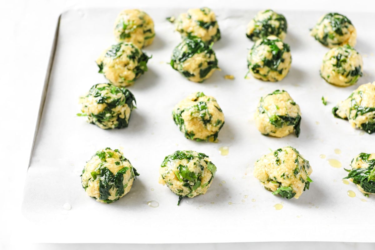 unbaked spinach balls on a baking sheet