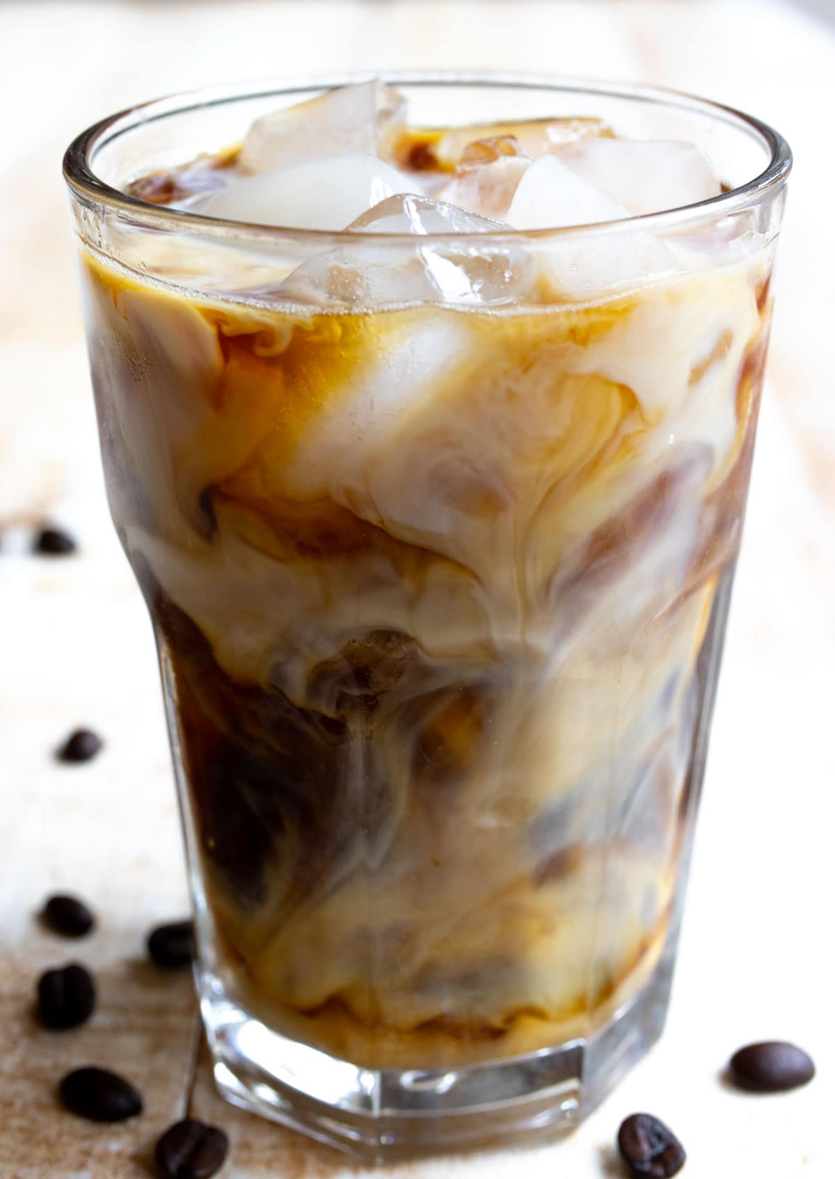 Cream swirls in iced coffee.
