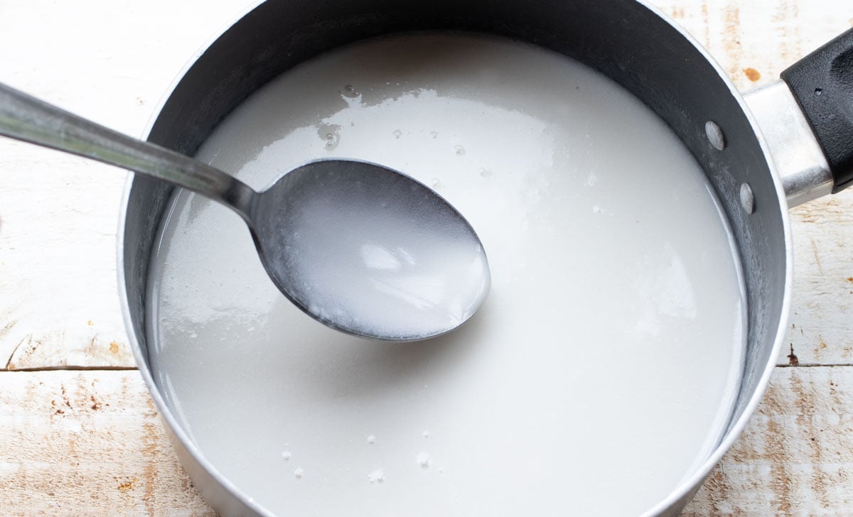 heated, liquid coconut milk in a pan