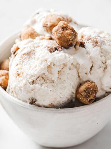 Scoops of almond milk ice cream in a bowl with cookie dough balls