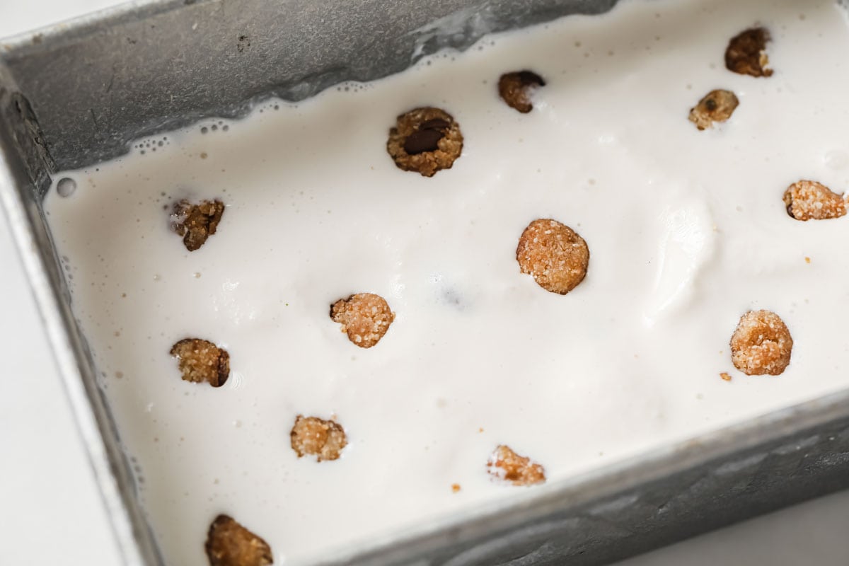 ice cream mixture with cookie dough bites in a rectangular tin