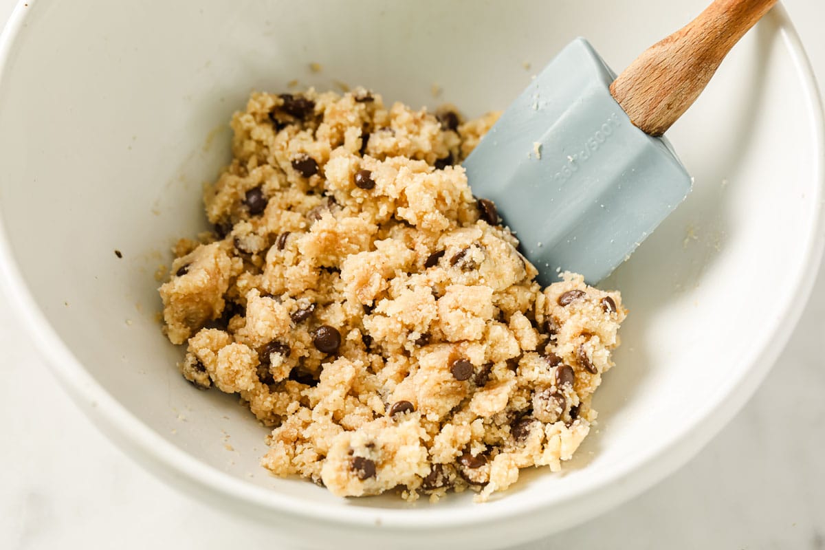 mixing the cookie dough with a spatula in a mixing bowl