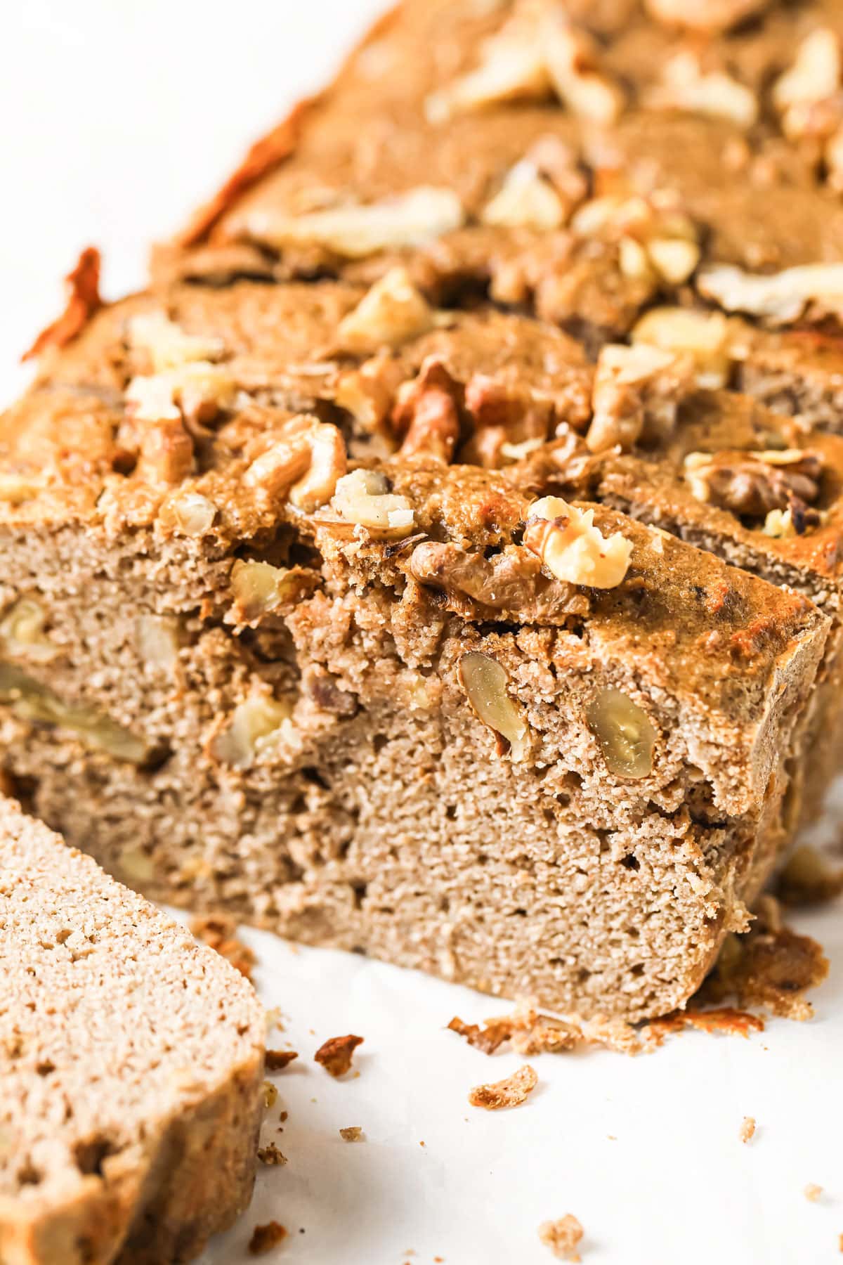 A loaf of banana bread sliced with walnuts.