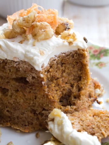 A carrot mug cake with cream cheese frosting on a plate.
