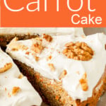 A slice of carrot cake topped with frosting and walnuts.