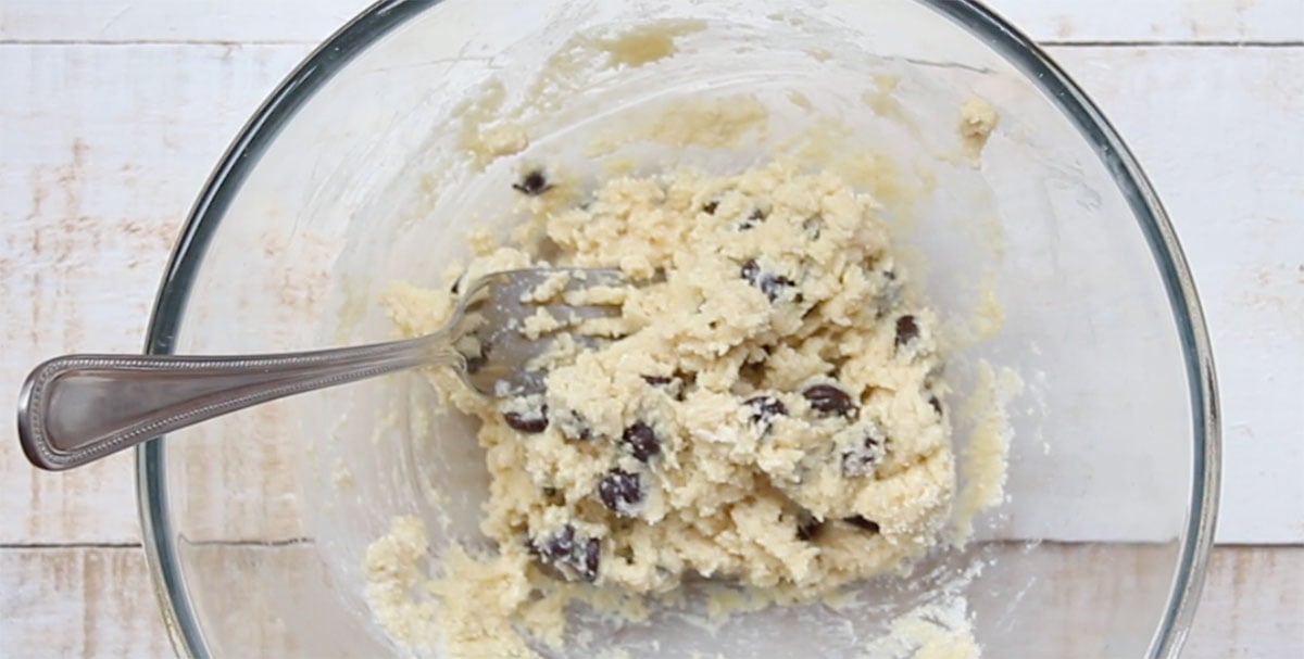 Chocolate chip cookie dough in a bowl with a fork.
