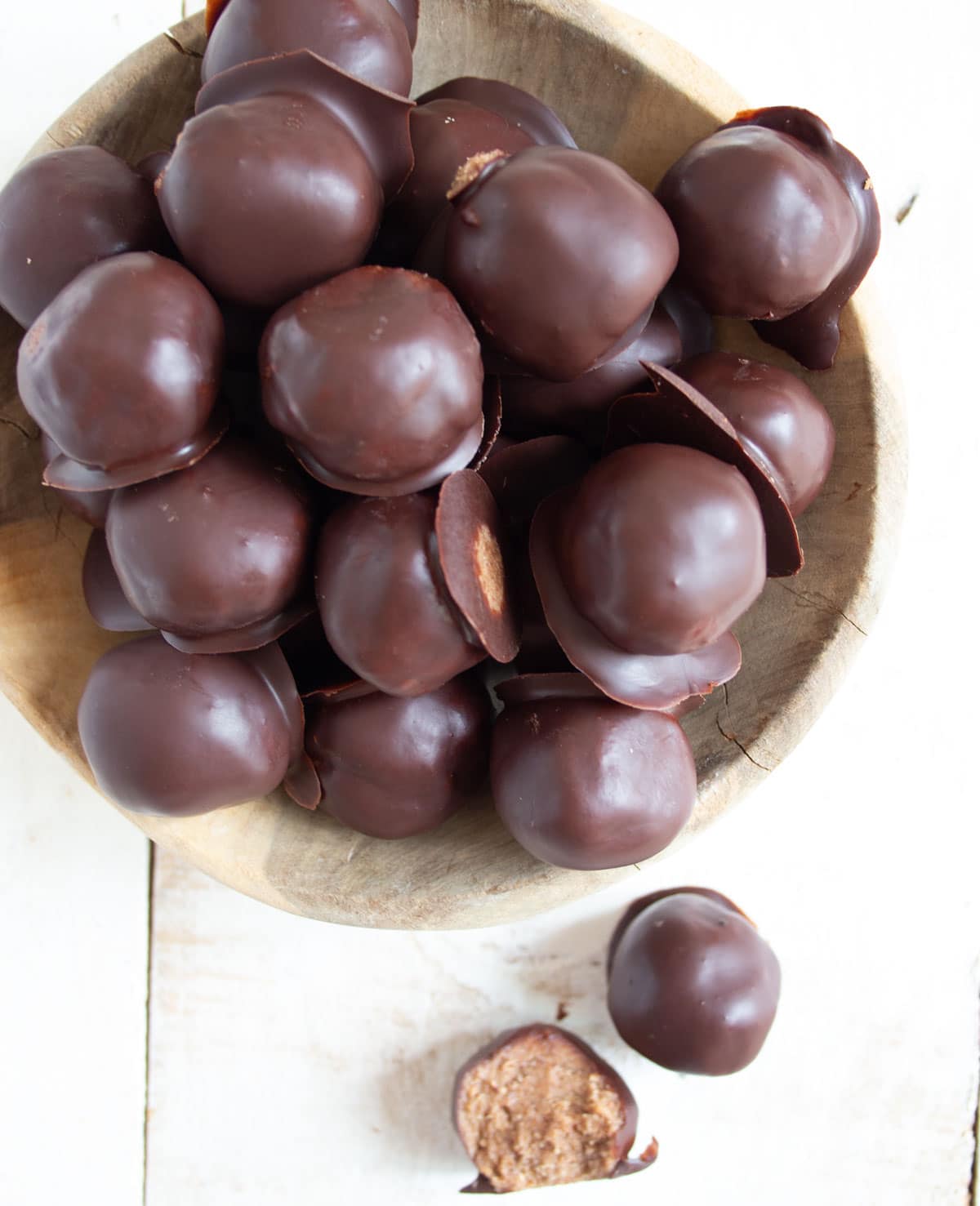 A bowl with truffles, one is halved, showing the inside.