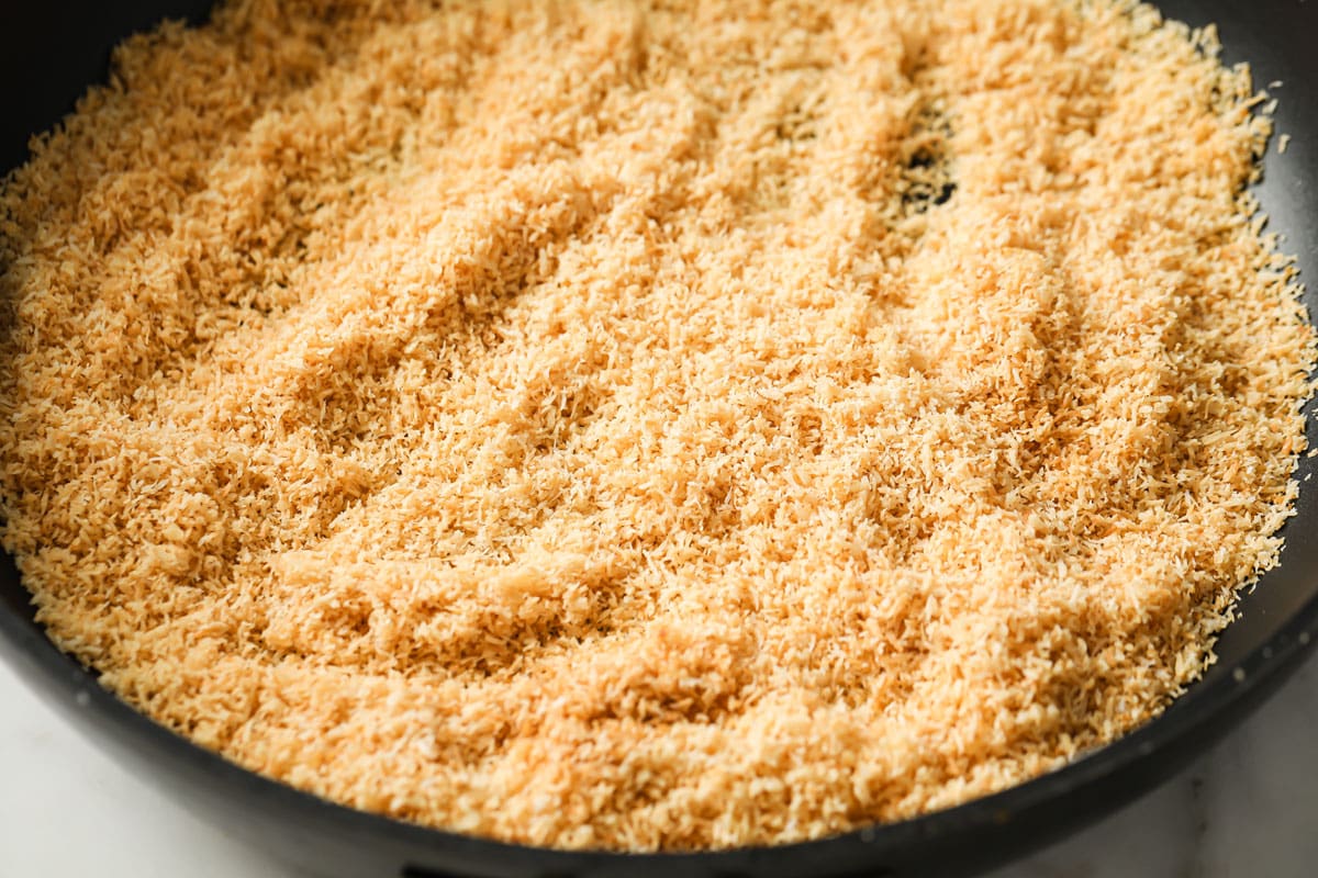 Golden roasted desiccated coconut in a pan.