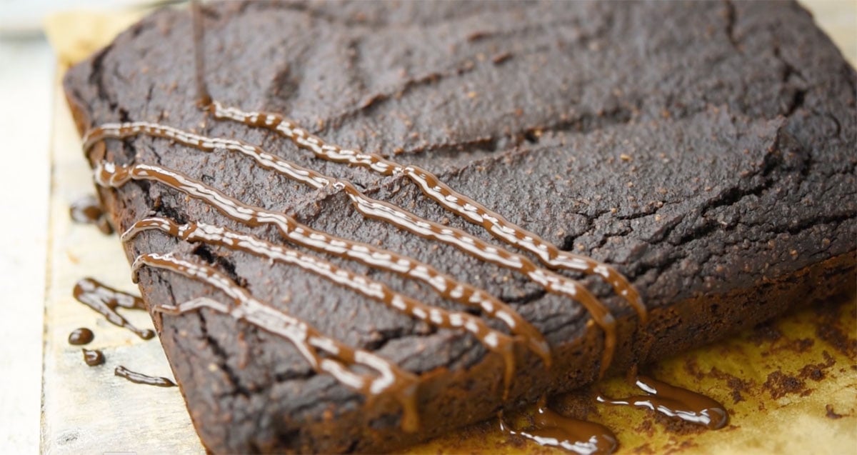 Drizzling melted chocolate on top of the baked brownie.