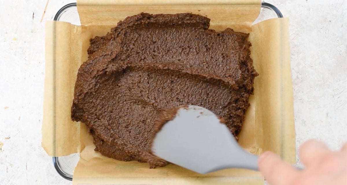 Spreading the batter into a parchment paper lined balking pan with a spatula.