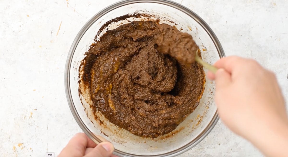 Mixing brownie batter in a bowl with a fork.