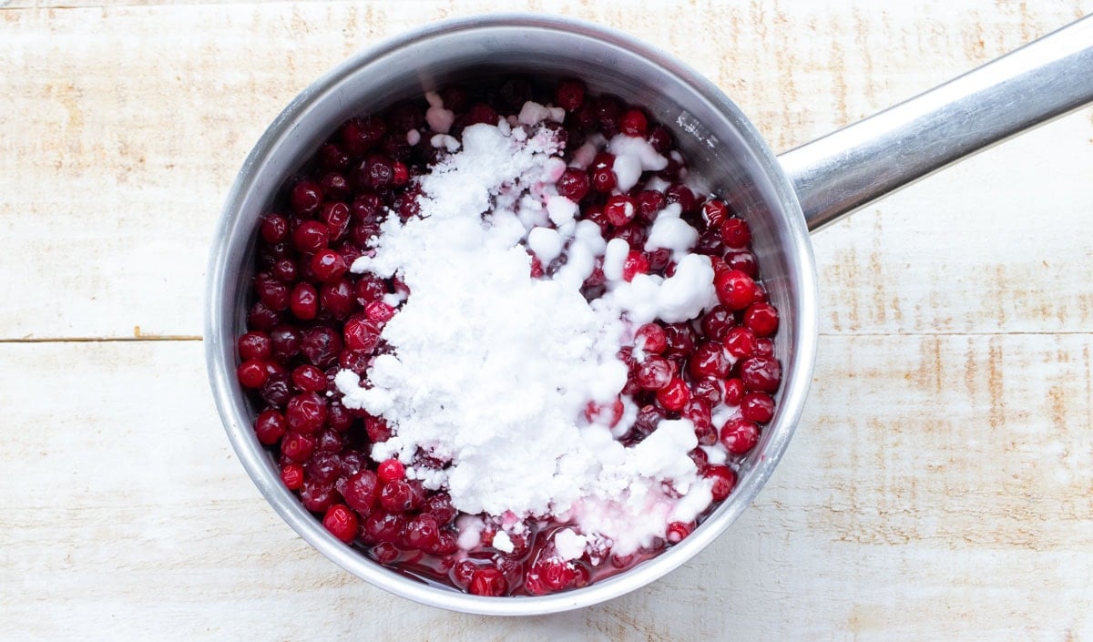 Cranberries and sweetener in a saucepan.