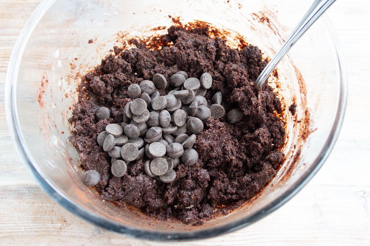 A bowl of chocolate cookie dough and chocolate chips.