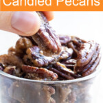 Hand taking a candied pecan.