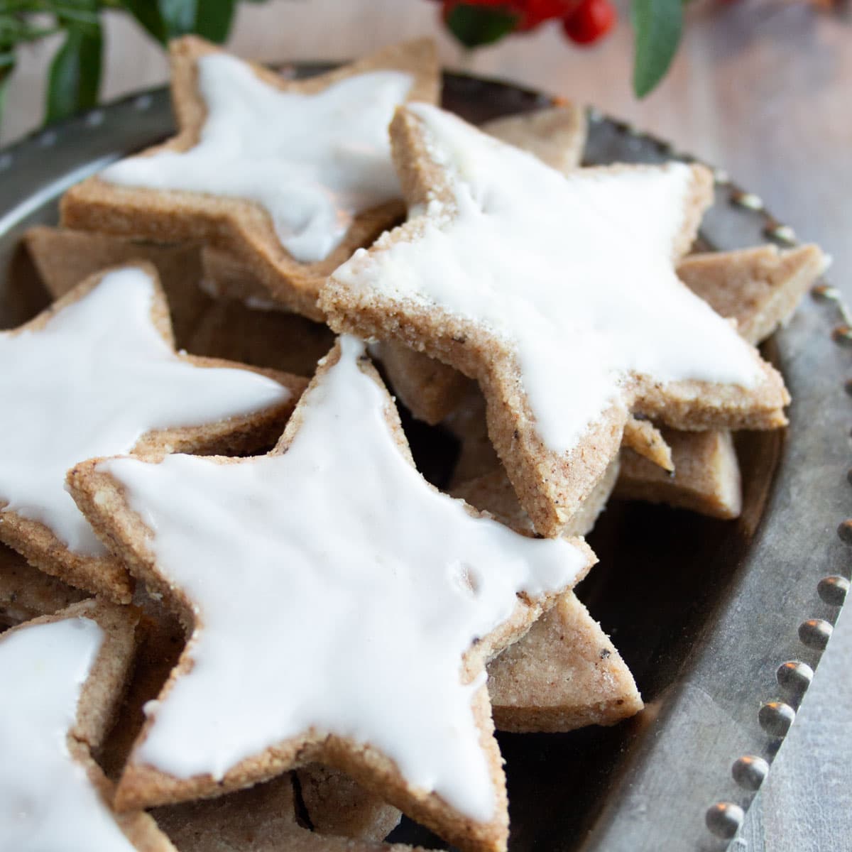 A silver tray with Christmas cookies - stars with white icing.