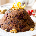 A christmas pudding topped with orange peel.