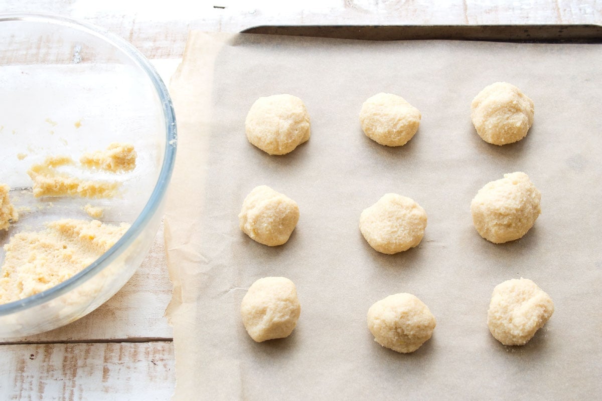 Cookie dough balls on a cookie sheet.