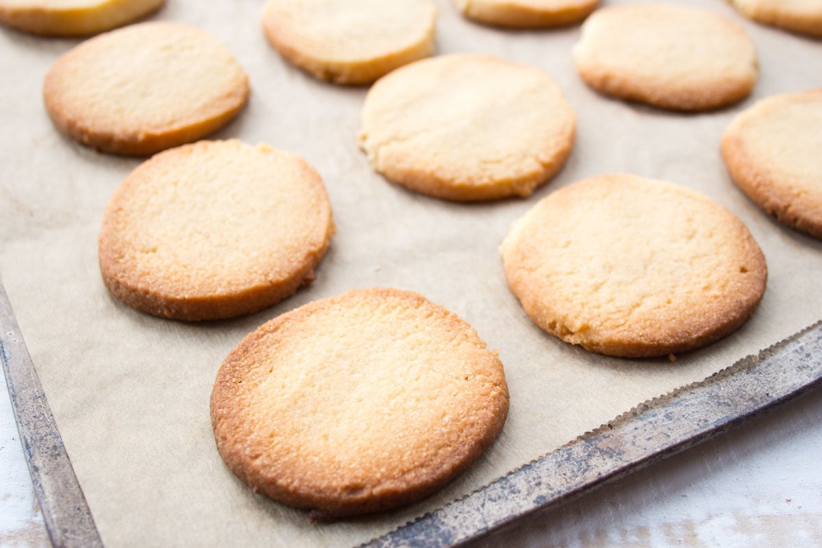 Baked cookies on a cookie sheet lined with parchment.