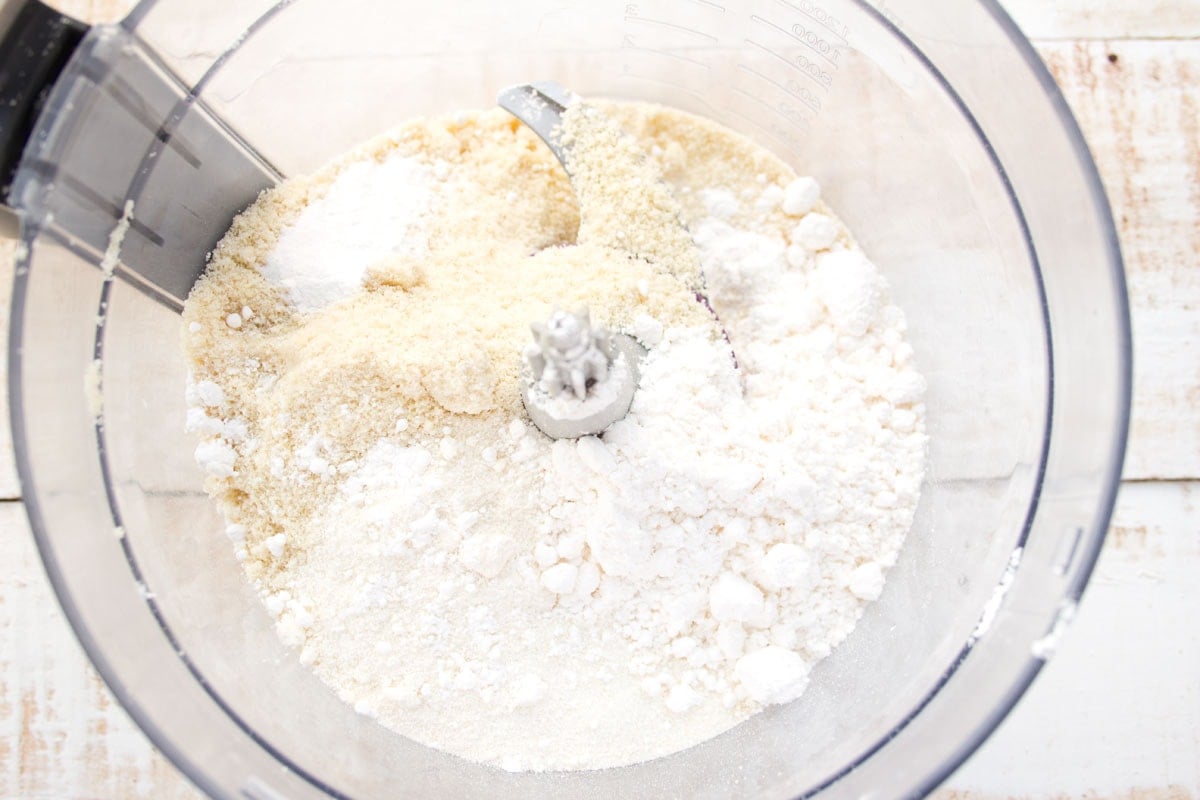 Dry ingredients in a food processor bowl before mixing.