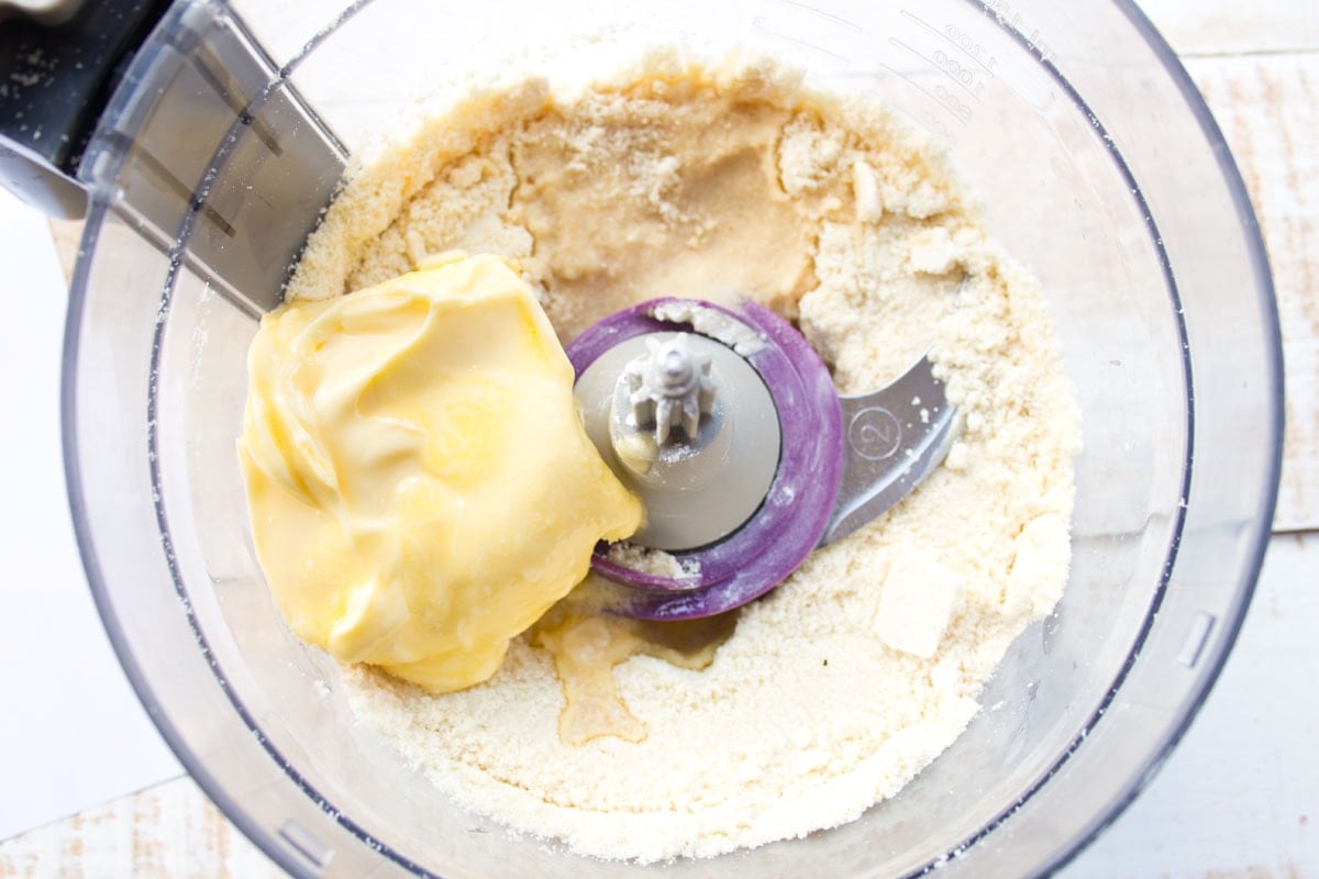 Dry ingredients and wet ingredients in a food processor bowl.