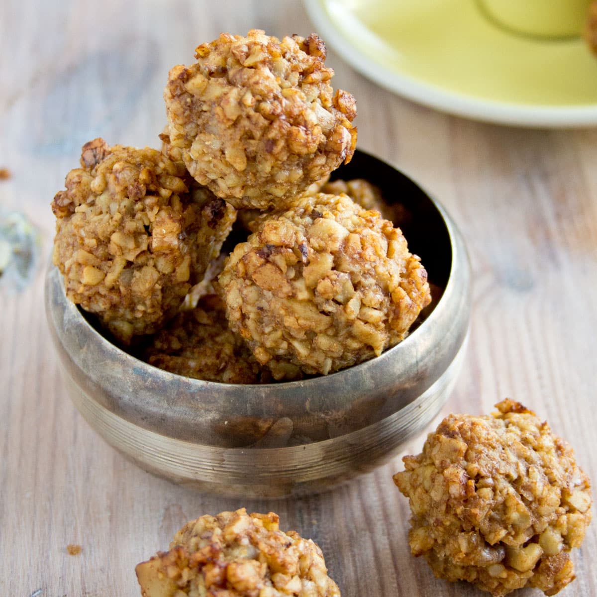 Walnut cookie balls in a silver bowl.