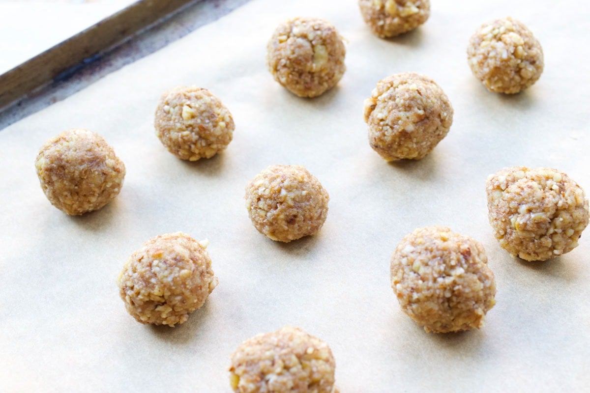 Unbaked cookies on a cookie sheet lined with parchment paper.