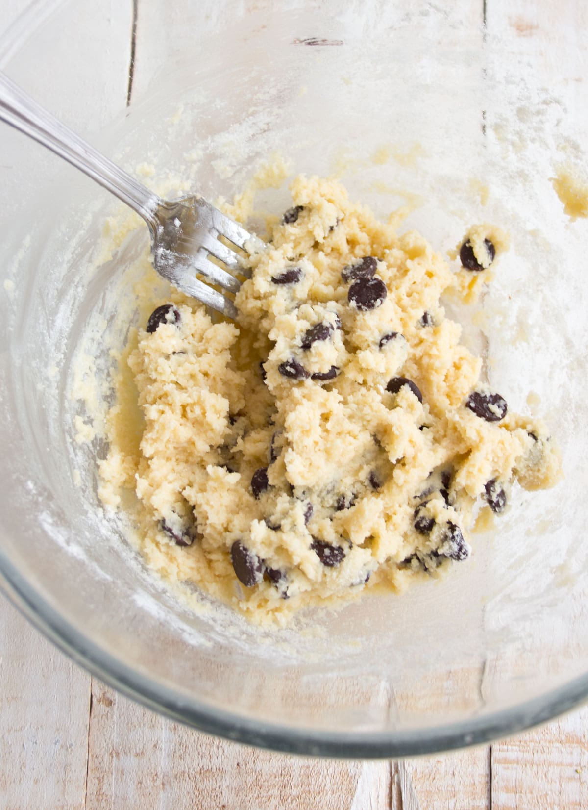A bowl with cookie dough and a fork.