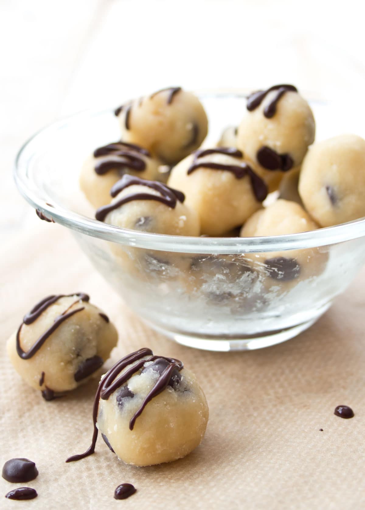 Cookie dough balls topped with chocolate drizzle.