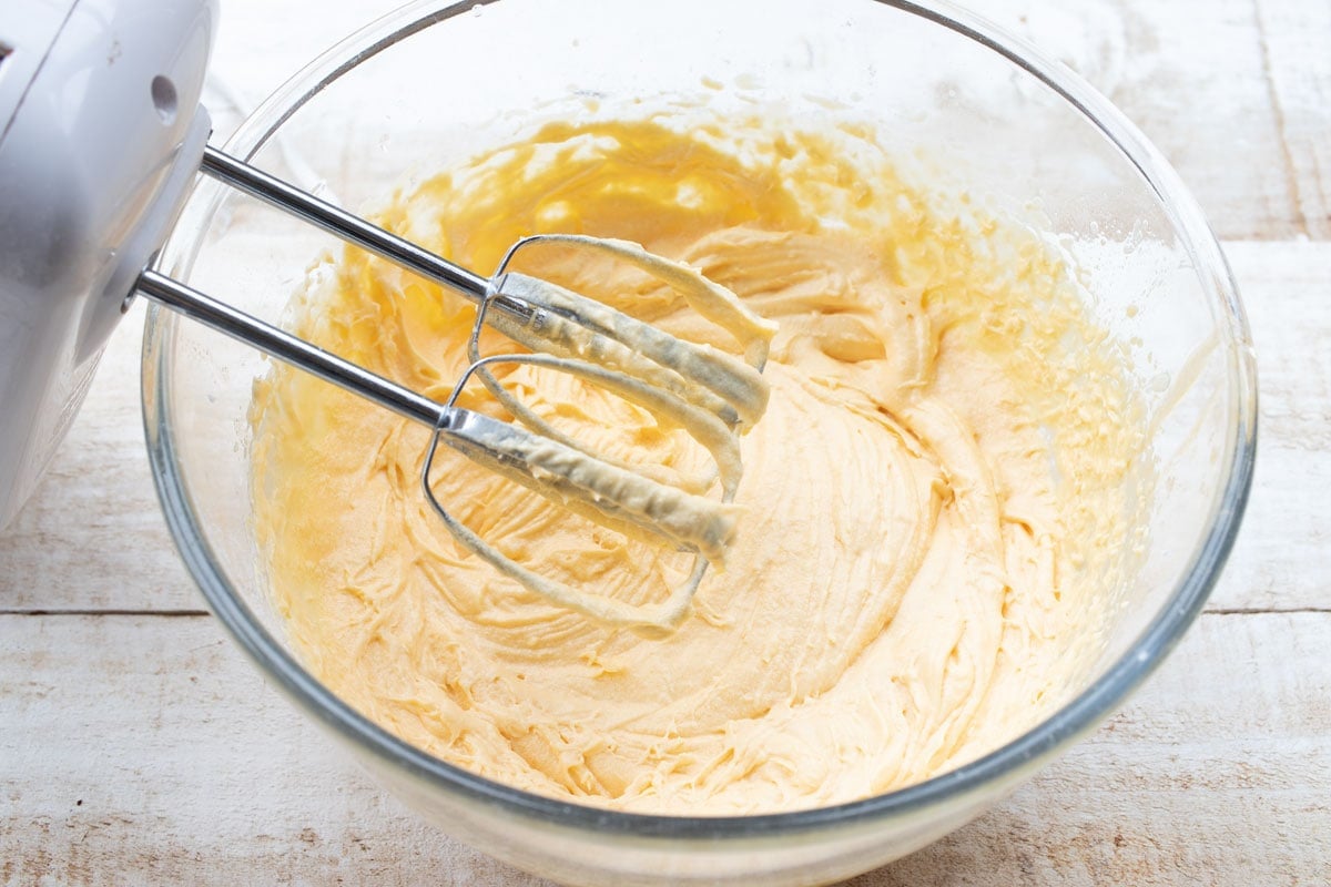 Whisking the cake batter with an electric mixer.