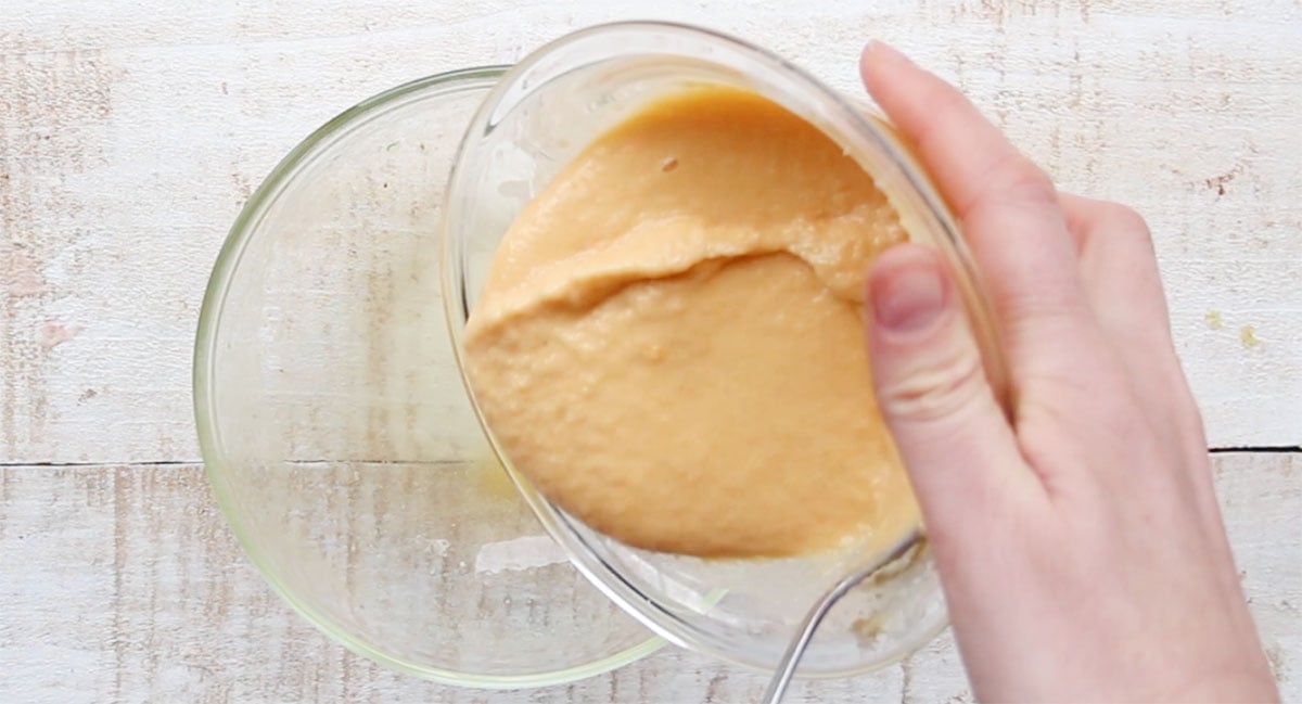 Pouring the cake batter into a greased bowl.