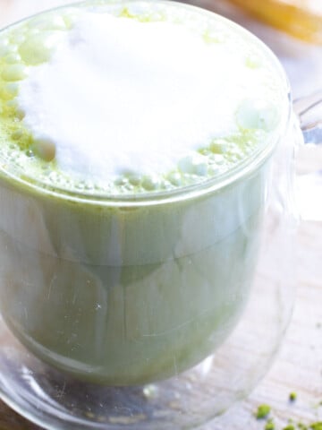A cup with almond milk matcha latte.
