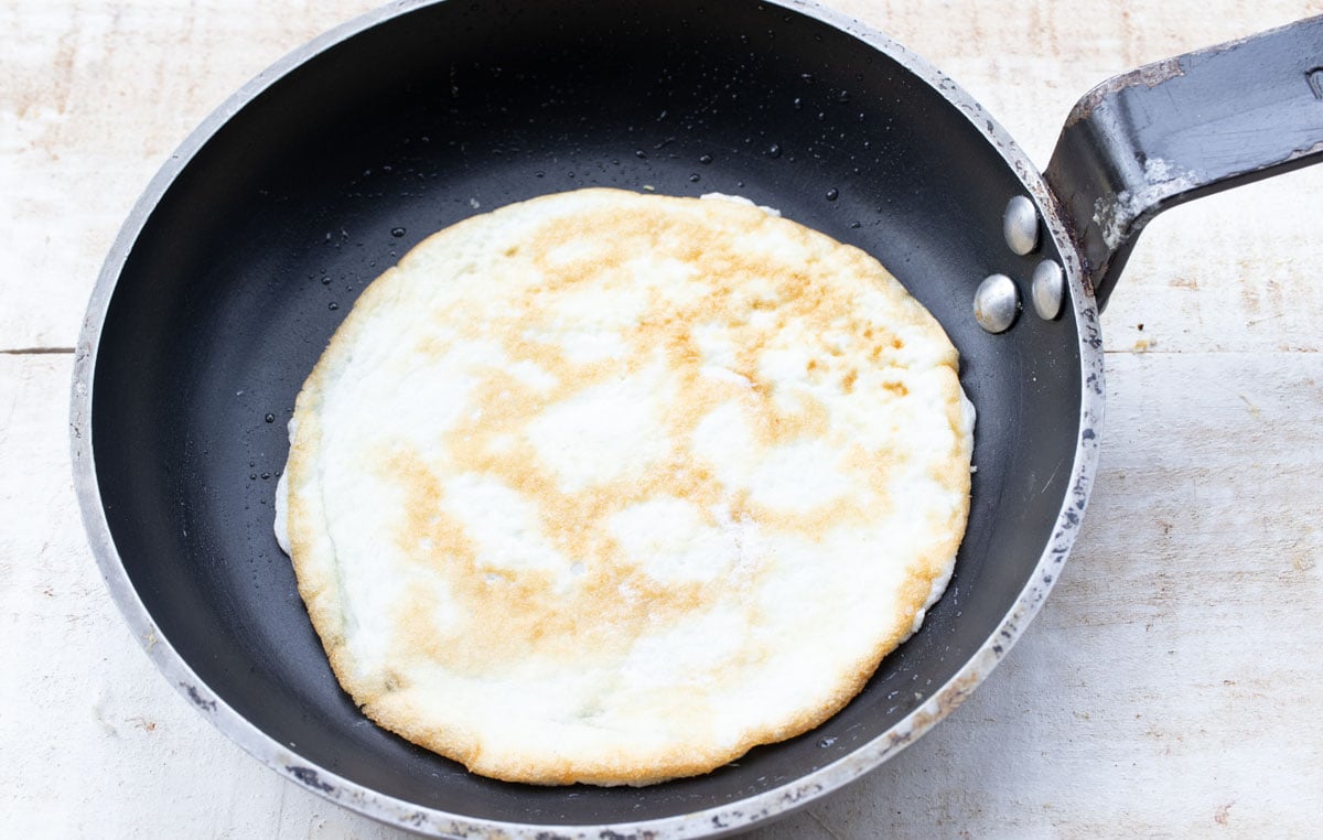 An egg white pancake in a frying pan.