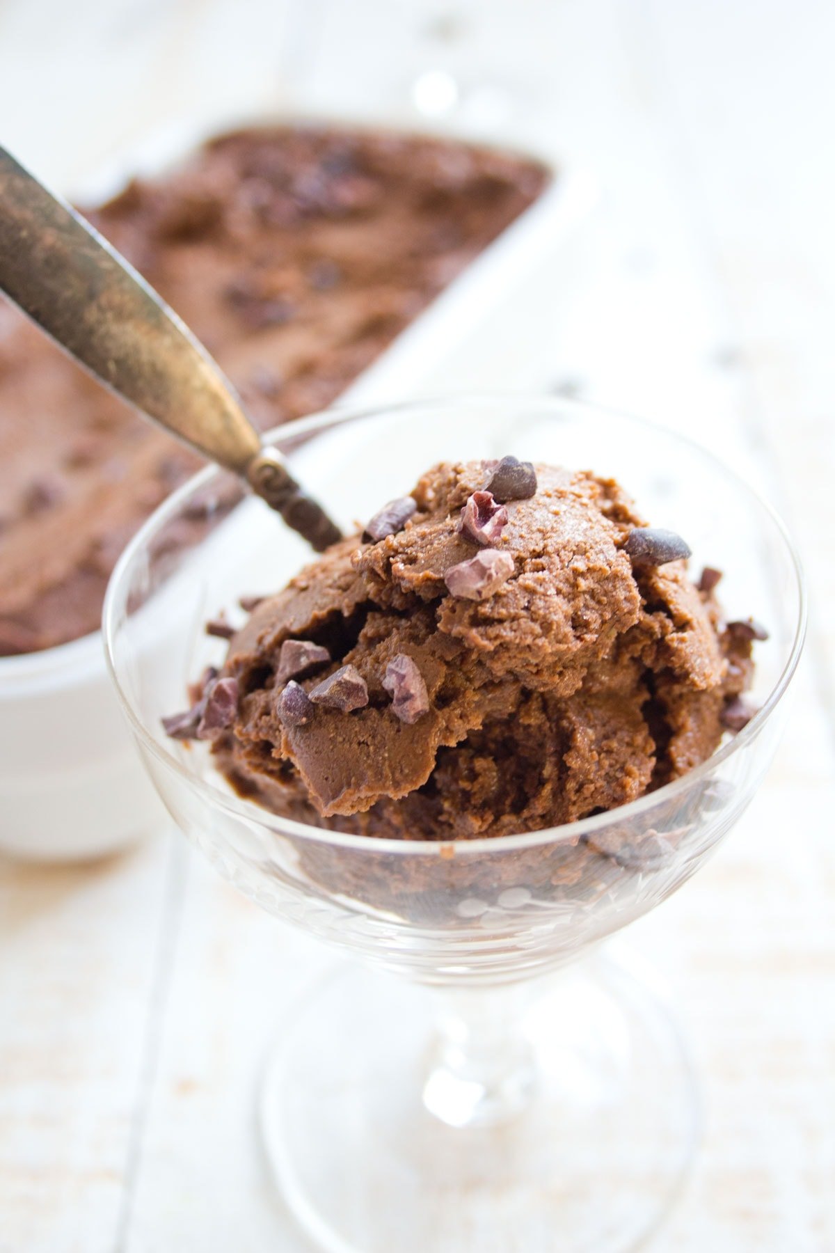 A glass bowl with chocolate ice cream.