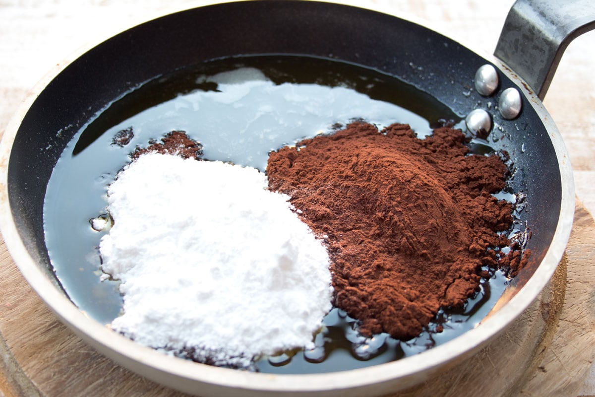 Adding sweetener and chocolate powder to melted cacao butter.