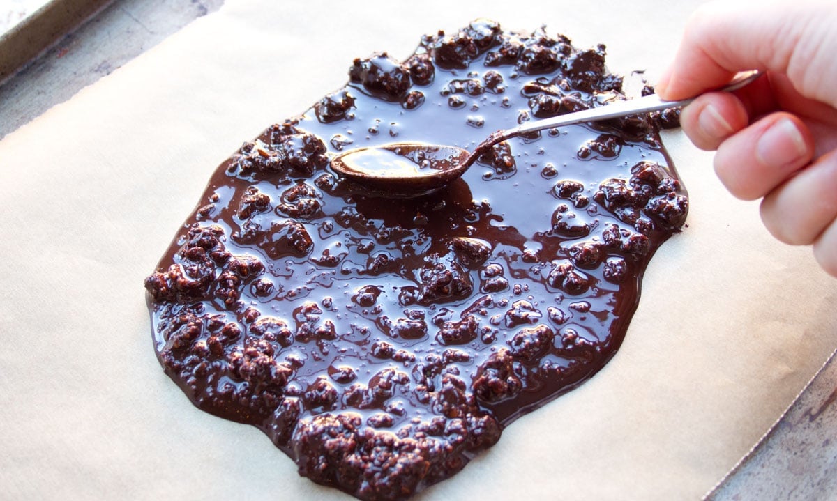 Spreading melted chocolate onto parchment paper.