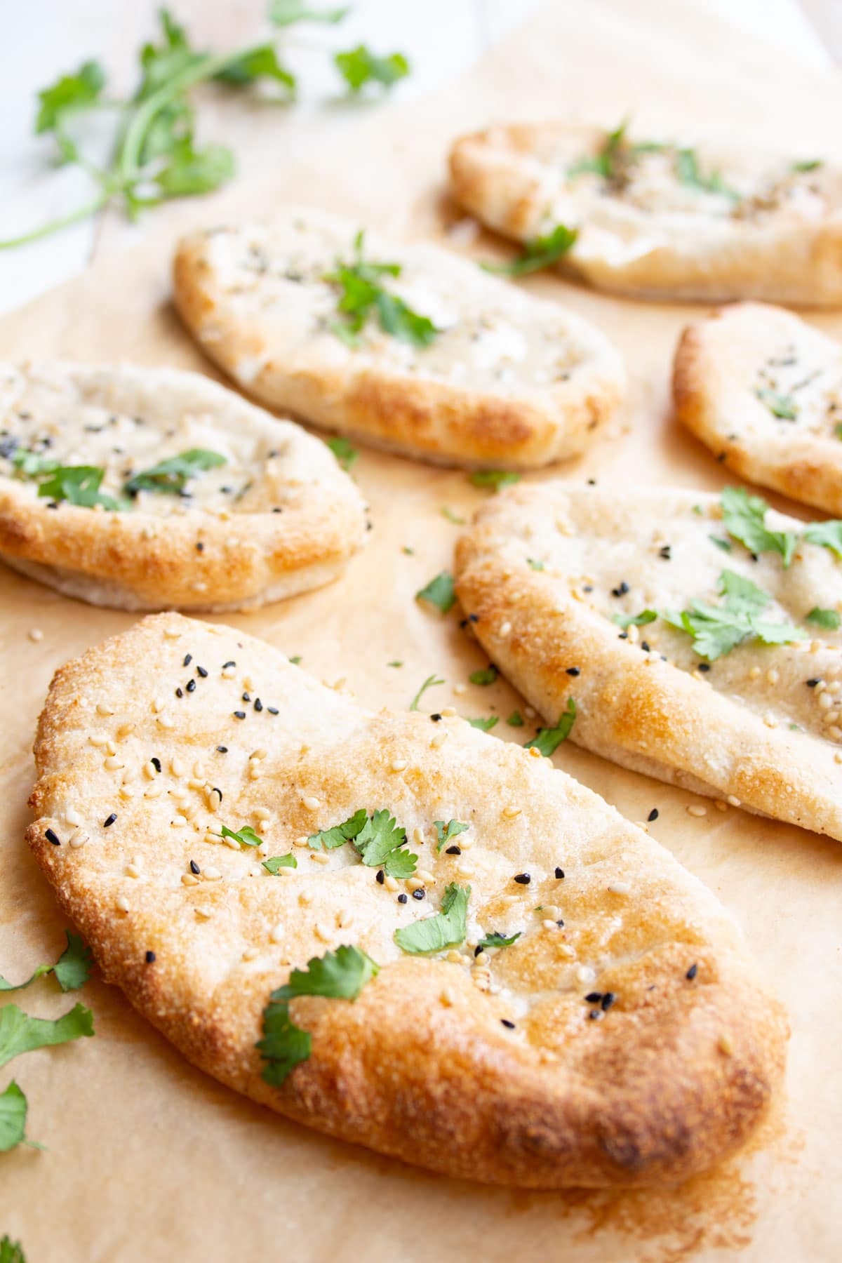 Naan breads on parchment paper.