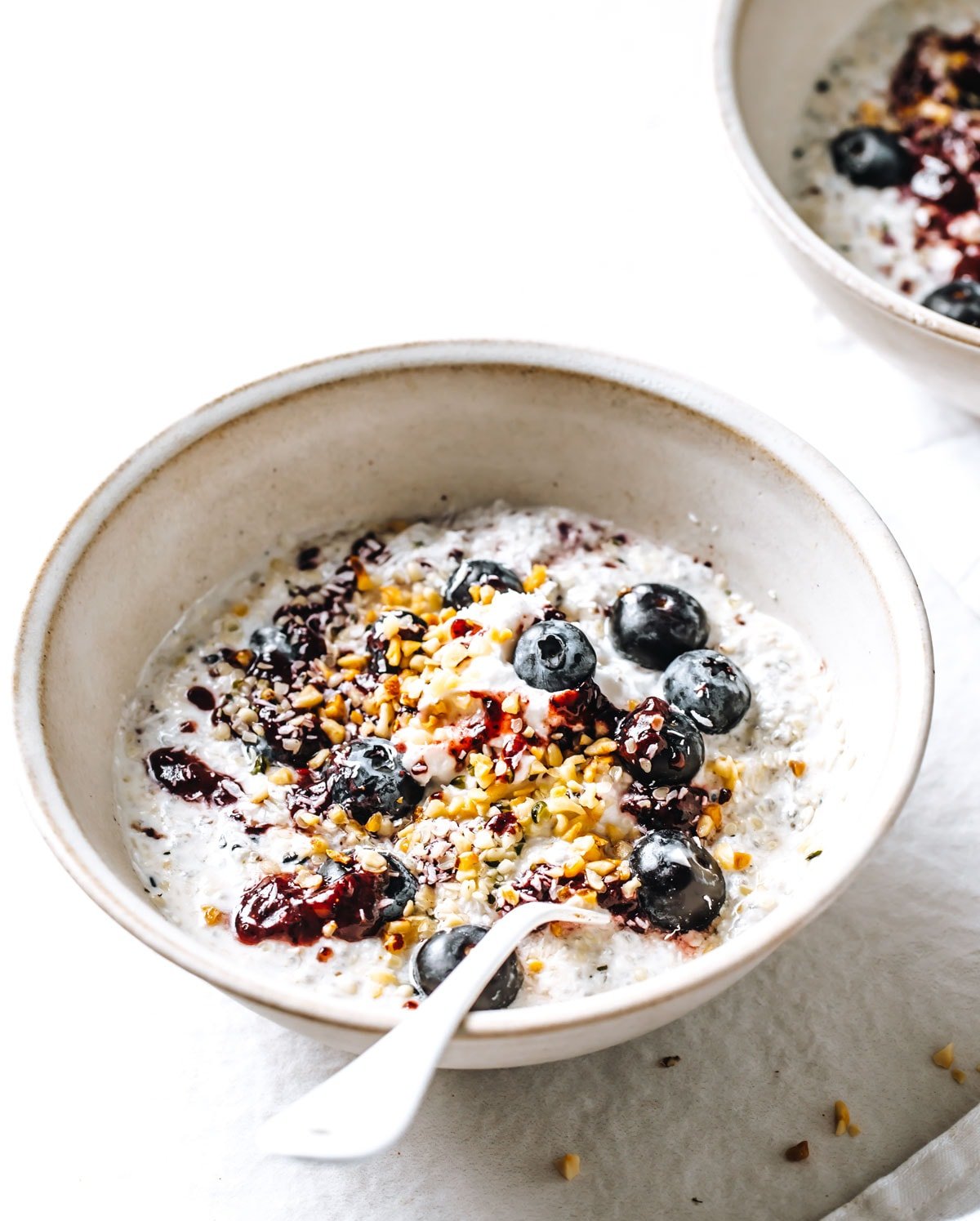 a bowl with overnight oats topped with berries and nuts.