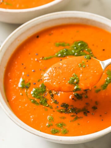 Tomato soup in a bowl toped with basil oil.