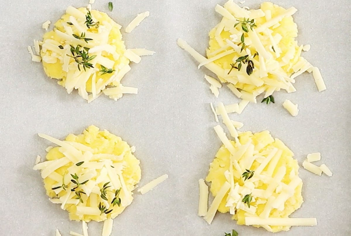 Topping the unbaked crackers with fresh thyme leaves.