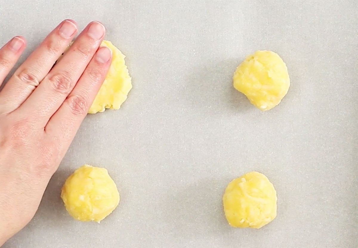 Hand pressing the dough backs into crackers.