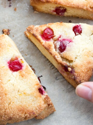Hand taking a cranberry scone.