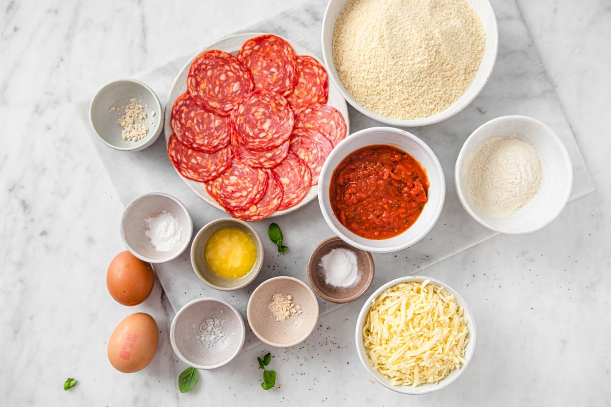 Ingredients to make an almond flour pizza crust measured into bowls.