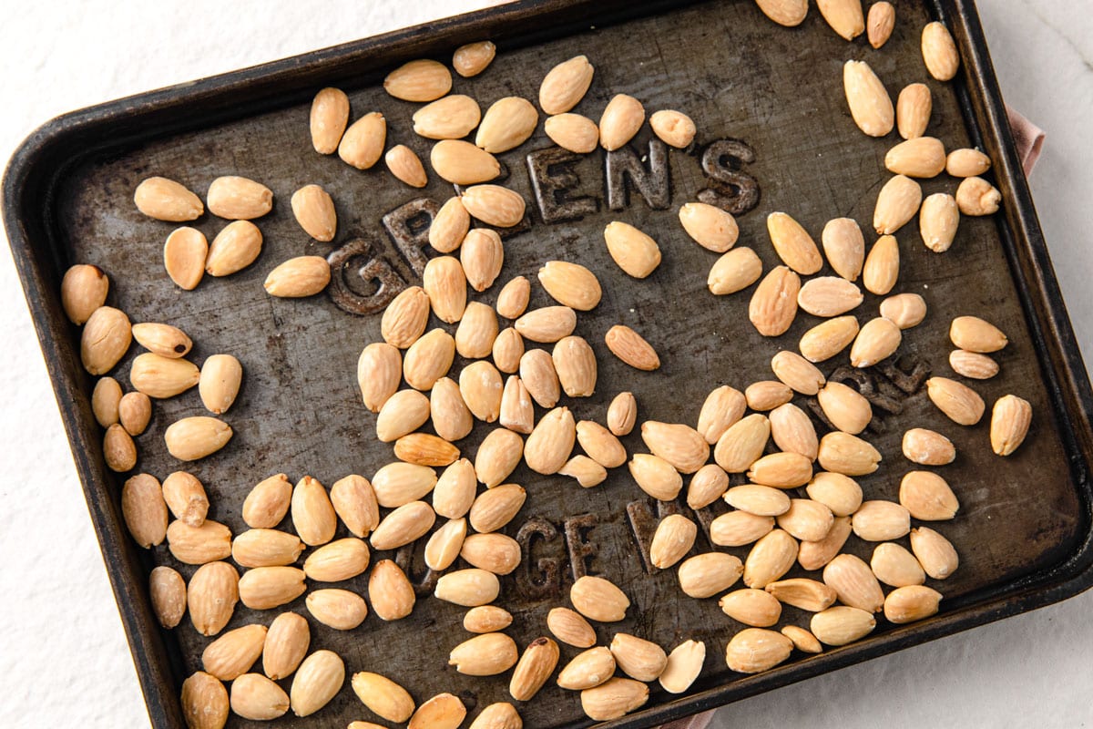Roasted whole almonds on a baking tray.