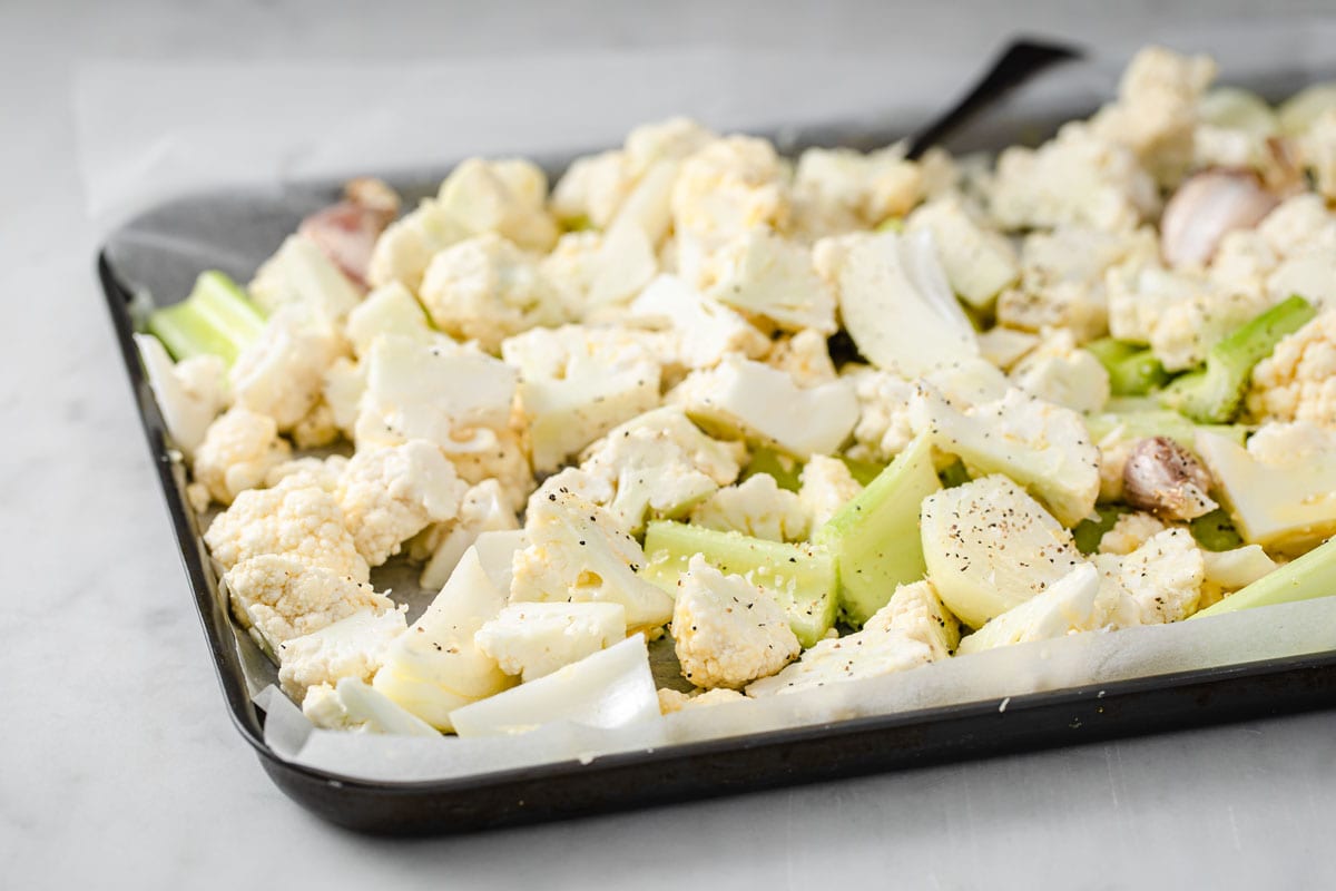 Chopped raw vegetables on a baking tray.